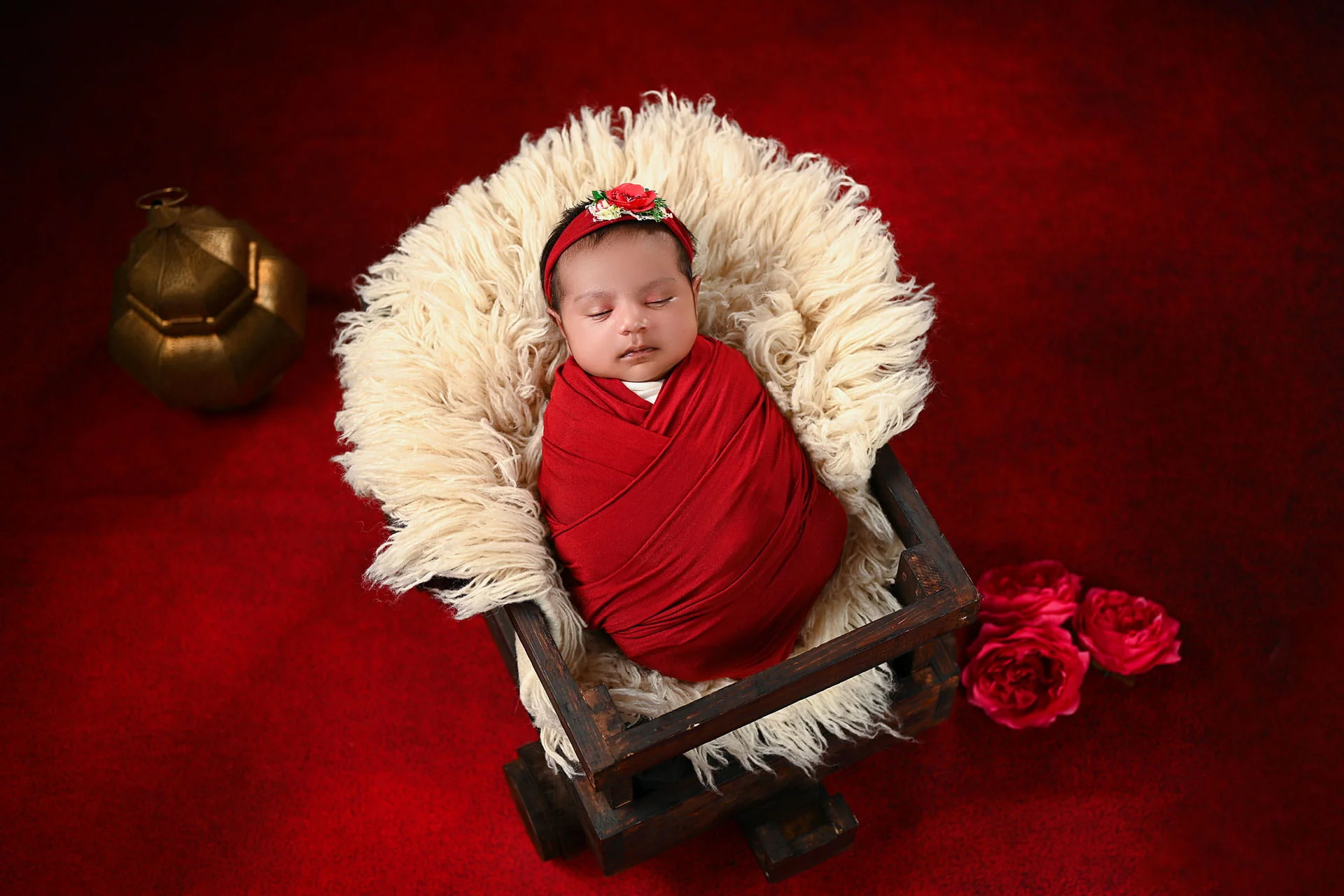 newborn in red wrap