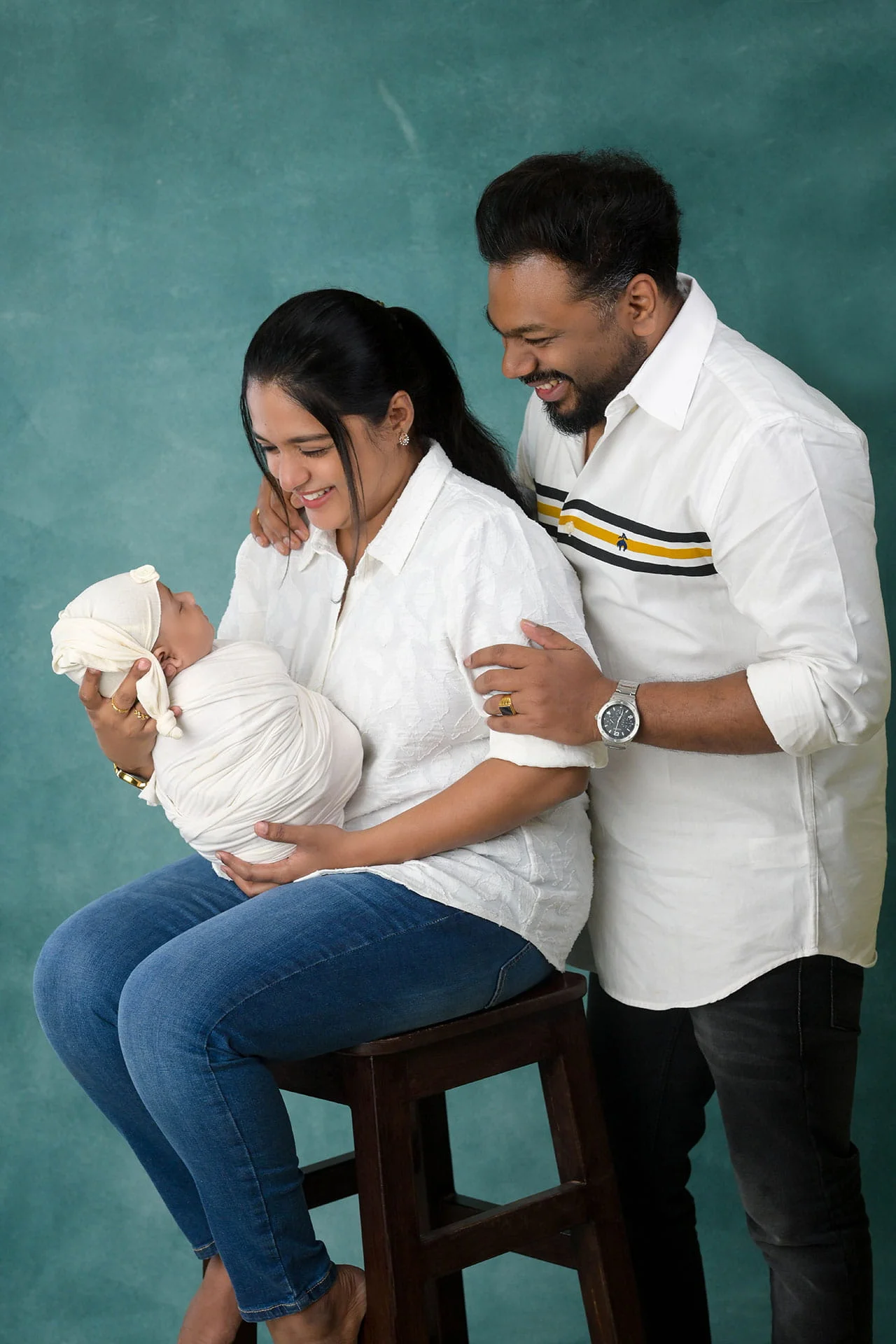family photoshoot with newborn in turquoise background and white costume